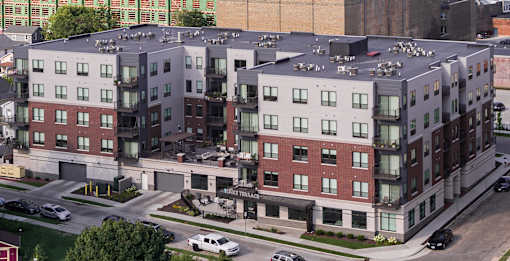 A large apartment complex with a parking lot in front.