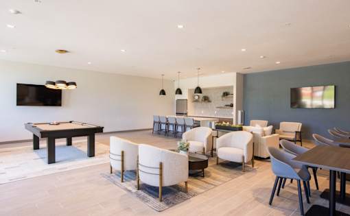 A modern living room with a pool table and comfortable seating.