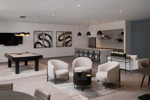A modern living room with a pool table and comfortable seating.