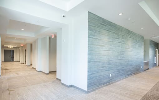 A long hallway with a blue wall on the side.