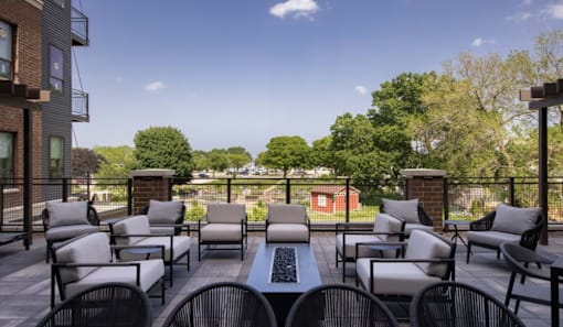 A patio with chairs and a table with a laptop on it.