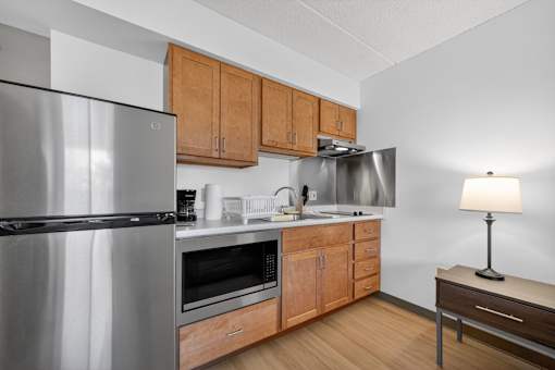 A modern kitchen with wooden cabinets and stainless steel appliances.