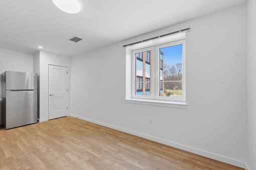 A white room with a window showing a view of a building outside.