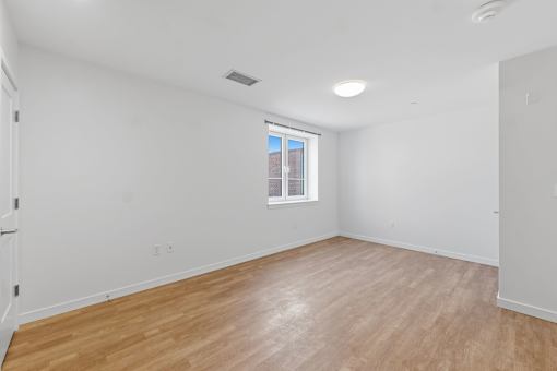 A room with wooden flooring and a window.