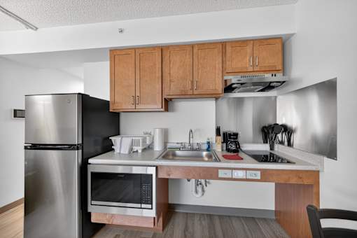 A kitchen with a stainless steel refrigerator, microwave, and oven.