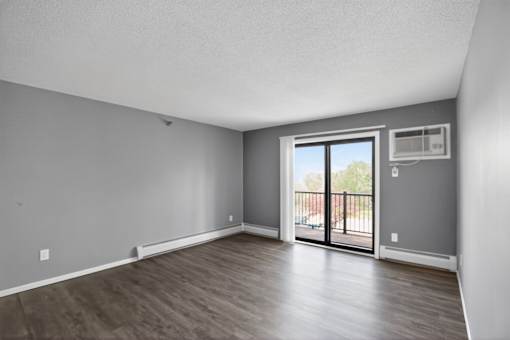 A room with a sliding glass door leading to a balcony.