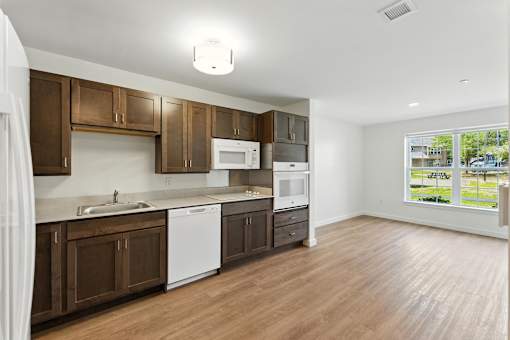 A kitchen with brown cabinets and white appliances.