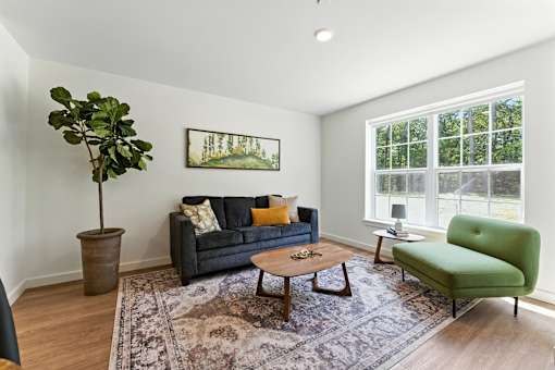 A living room with a green chair and a brown tree.