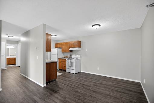 A kitchen with white appliances and wooden cabinets.