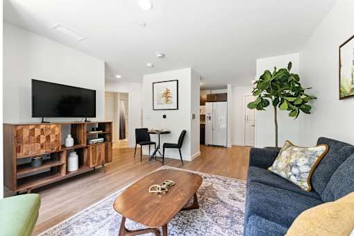 A living room with a blue couch and a wooden coffee table.