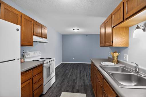 A kitchen with white appliances and wooden cabinets.