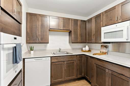 A kitchen with brown cabinets and white appliances.