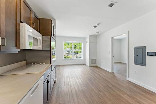 A modern kitchen with wooden floors and a large window.