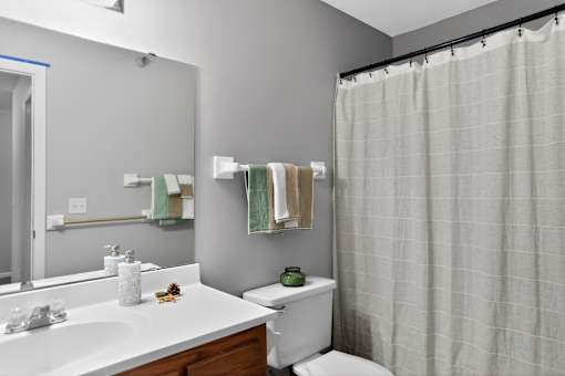 A white bathroom with a toilet, sink, and shower.