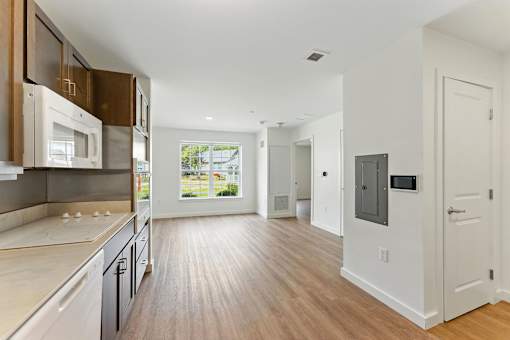 A modern kitchen with wooden floors and white walls.