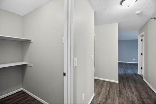 A room with a white door and a grey wall.