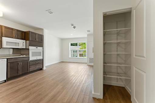 A kitchen with white appliances and wooden cabinets.