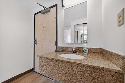 A bathroom with a sink and a mirror.
