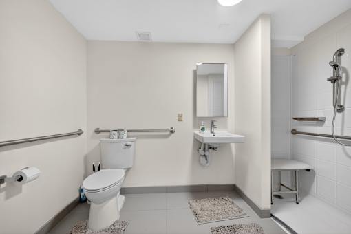 A white toilet sits next to a white sink in a bathroom.