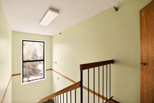 A room with a window and a staircase.