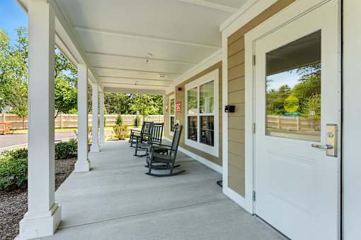 A porch with white columns and a white door.