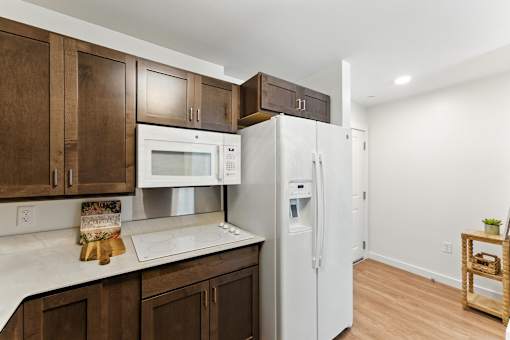 A kitchen with brown cabinets and a white fridge.