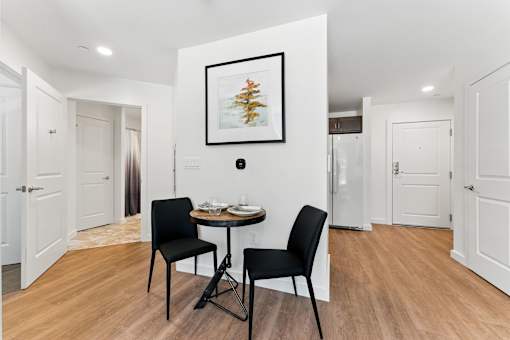 A dining room with a table and two chairs.