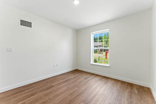 A room with a window and a picture on the wall.