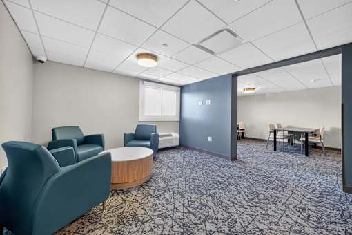 A conference room with a carpeted floor and a round table.
