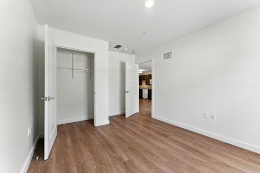 A long hallway with white walls and wood floors.