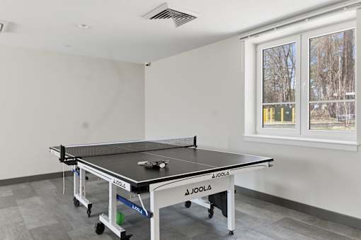 A JOOLA table tennis table in a room with a window.