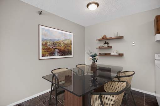 A dining room with a glass table and chairs.