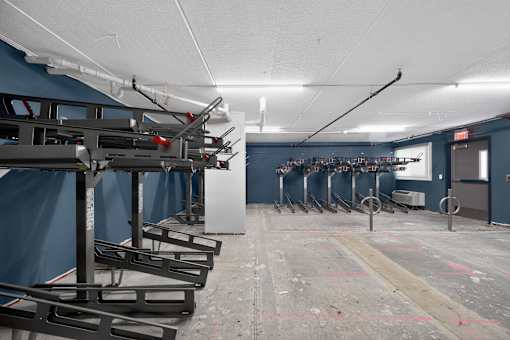 A row of basketball hoops are lined up in a gym.