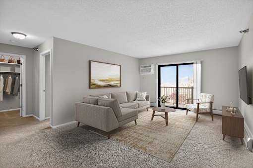 A living room with a grey couch, a brown rug, and a painting on the wall.