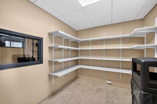 Empty room with shelves and a mirror on the wall.