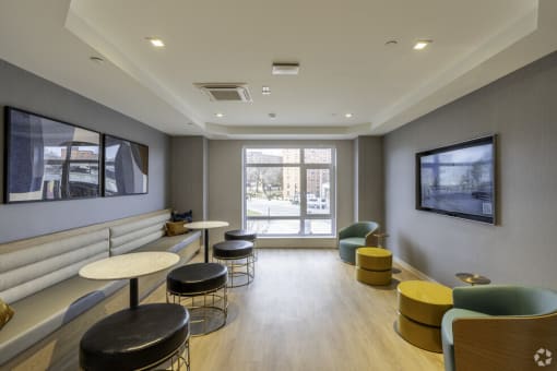 a waiting room with tables and chairs and a television