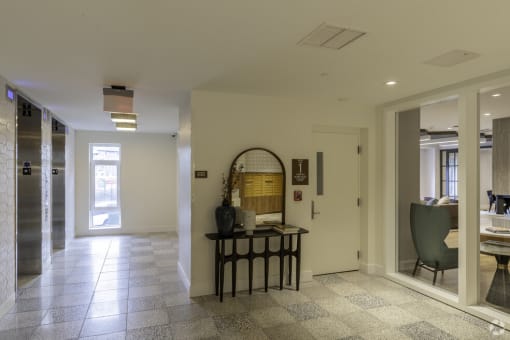 a hallway with a table and a mirror in the middle