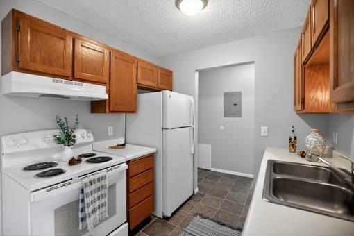 A kitchen with white appliances and wooden cabinets.