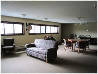 A living room with a couch, chairs, and a table.