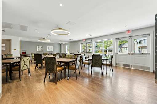 A room with tables and chairs and a white ceiling.