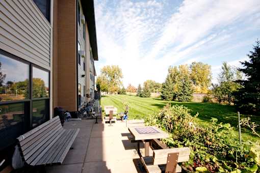 A bench is on the patio of a building.