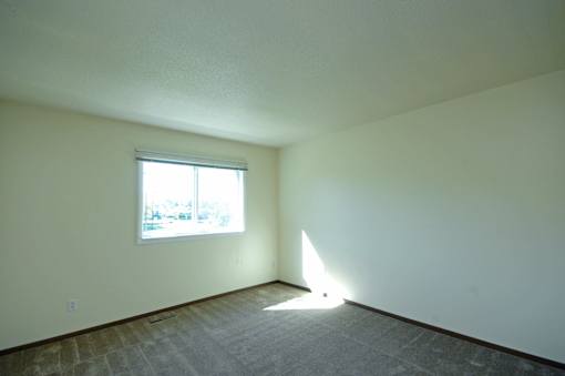 A room with a window and sunlight coming through.