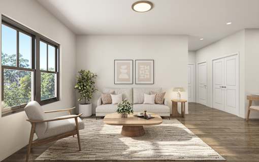 A living room with a sofa, a chair, a coffee table, and a potted plant.