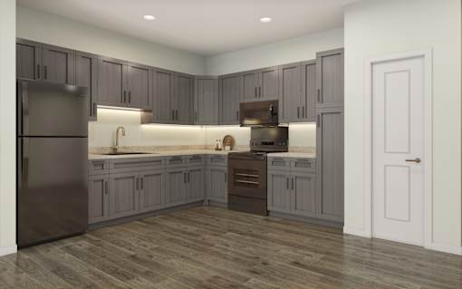 A modern kitchen with wooden floors and grey cabinets.