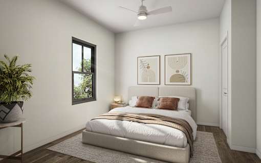 A bedroom with a large bed and a plant on the side table.