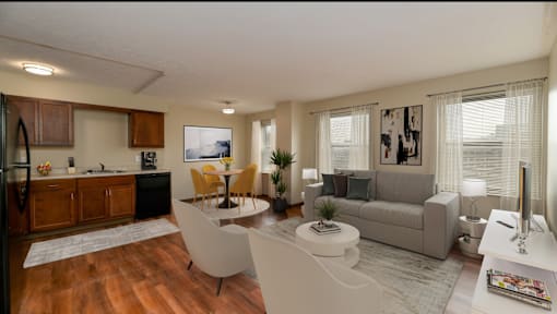 A modern living room with a kitchen area in the background.