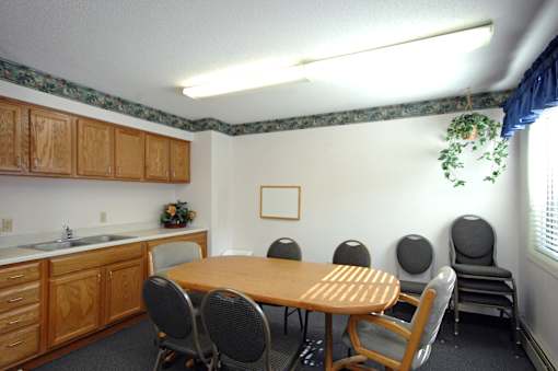 A conference room with a table, chairs, and a plant.