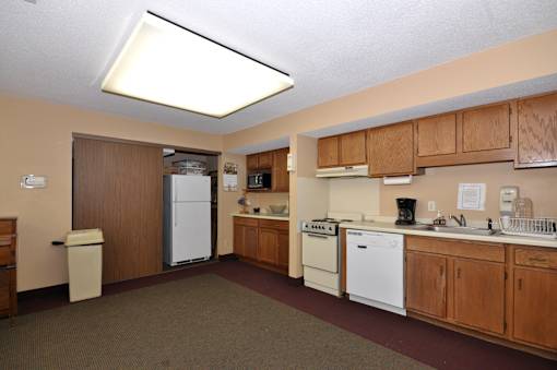 A kitchen with brown cabinets and white appliances.