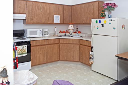 A kitchen with a white fridge and wooden cabinets.