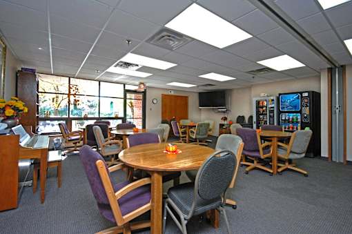 A conference room with a table surrounded by chairs.